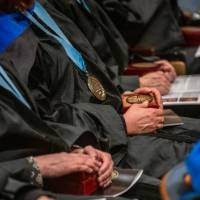 Faculty sit with their awards in their laps